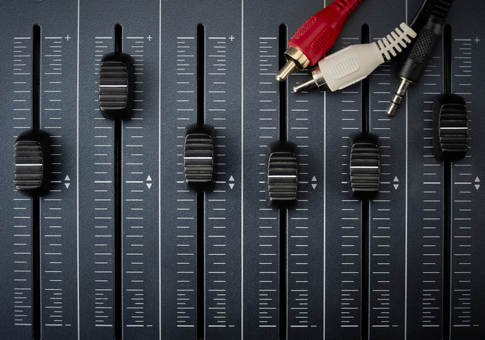 audio cables with rca connectors on faders of a mixer for audio production
