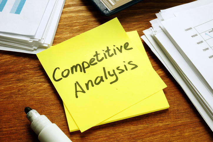 Competitive Analysis report and stack of business papers.